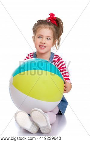 Little Girl Is Playing With A Ball.the Concept Of Childrens Sports, Summer Outdoor Recreation.