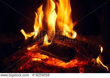 A Fire Burns In A Fireplace, Fire To Keep Warm. Logs Burning In