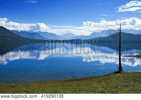 Mountain And Blue Cloudy Sky Reflection Ont He Lake