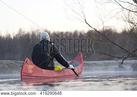Man Rowing A Canoe In Early Spring In The Early Morning. Lifestyle. Morning Landscape, Fog By The Mo
