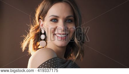 Portrait of young caucasian woman on brown background