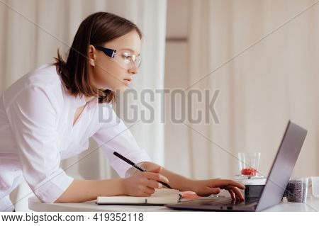 Scientist Is Conducting Experiments, Tests With Plants In Petri Dish At Laboratory. Biotechnologist 