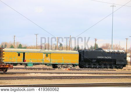 April 26, 2021 In Cheyenne, Wy:  Vintage Locomotive And Rail Car On A Train Track Taken At A Railroa