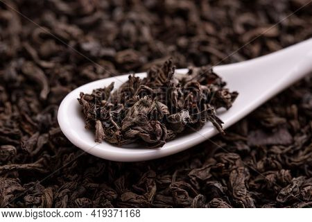 Tea Leaves Close Up. Tea In A Ceramic Spoon. A Scattering Of Tea Leaves. Black Leaf Tea Close Up.