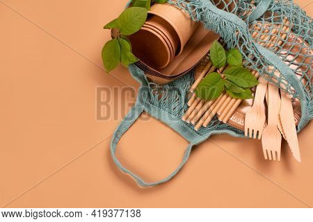 Kraft Paper Food Cups And Containers With Wooden Cutlery In Cotton Net Bag On Kraft Paper Background