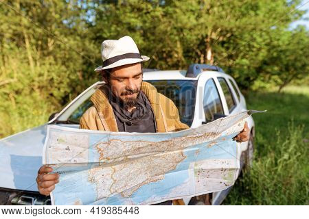 Latino Man Leaning On His 4wd Suv Car Consulting On A Map The Route Through The Forest To Follow. Lo