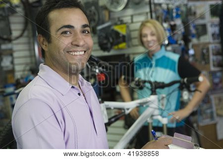 Portrét happy shop chovatel s cyklista v obchodě