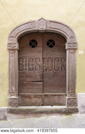 Beautiful Front Door. A Very Old Door To One Of The Thousand-year-old Houses In Barga. Door With Rou