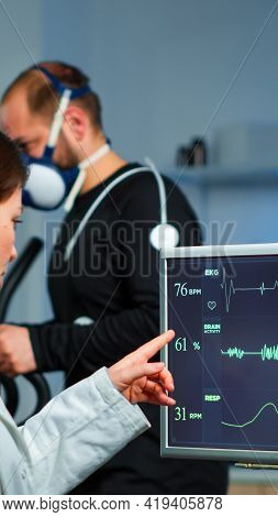 Muscular Athlete With Mask Running On Cross Trainer In Medical Laboratory