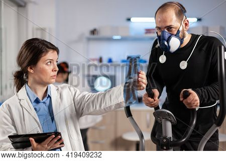 Medical Researcher Examining Evolution Of Athletes Health Condition