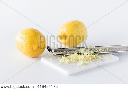 Lemon Zest With A Microplane And Two Lemons In Behind.