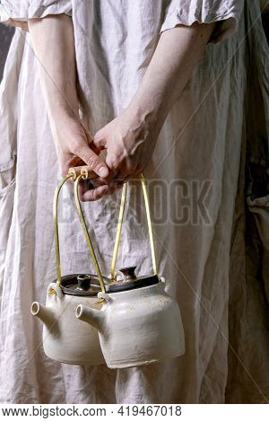Female Holding Two White Handmade Ceramic Teapots