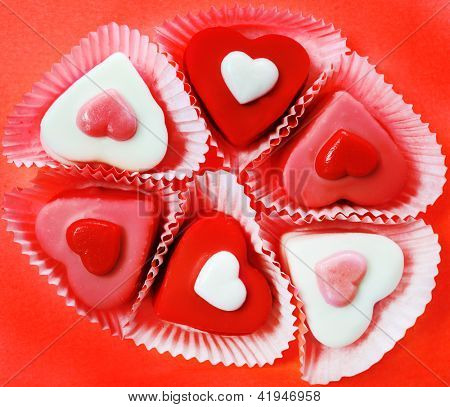 Caramelle a forma di cuore sul rosso