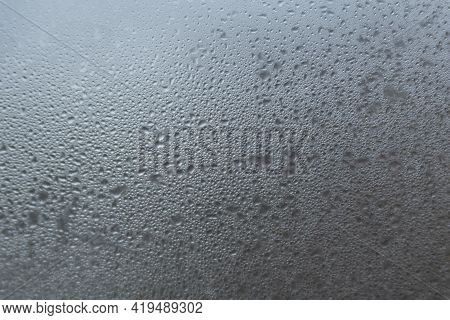 Window Glass With Drops Of Water. Abstract Gray Background With Drops And Stains. Inclement Weather.