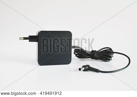 Black Power Ac To Dc Adaptor. Power Adapter Of Computer On Background.