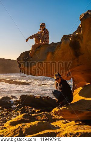 A Young Woman Looking At The Sea At Sunset In The Cove Of Stones On The Mountain Of Jaizkibel In The