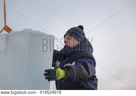 Slinger In A Blue Jacket Unloading Ice Blocks
