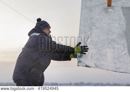 Slinger In A Blue Jacket Unloading Ice Blocks