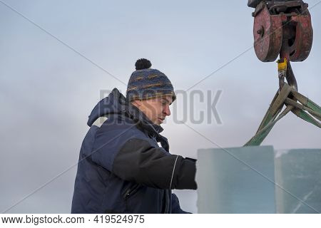 Slinger In A Blue Jacket Unloading Ice Blocks