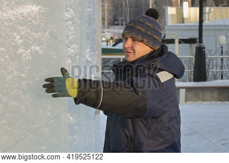 Slinger In A Blue Jacket Unloading Ice Blocks