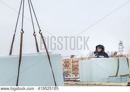 Slinger In A Blue Jacket Unloading Ice Blocks
