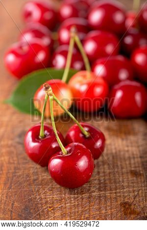 Cherries On Wooden Table With Water Drops Macro Background