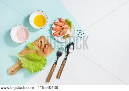 Fresh Summer Vitamin Appetizer Of Green Salad, Shrimps, Olive With Shadow In Sunlight On White Wood 