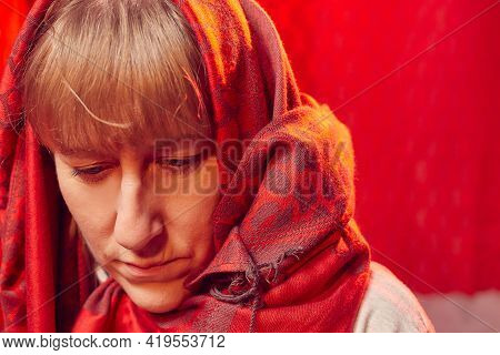 Portrait Of Sad Middle-aged Woman With Red Scarf On A Red Background. Unprofessional Female Model Cl