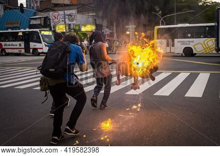 MedellÍn, Colombia - May 03, 2021: A Person Carries A Burning Object To Barricade The Street. Days O