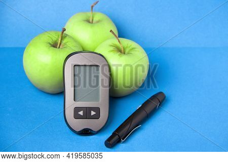 A Device That Measures Glucose In The Blood. Glaucometer With Green Apples.
