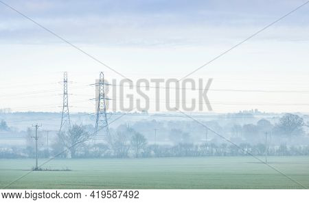 Electricity Pylons In A Uk Landscape On A Misty Morning. Aylesbury Vale, Buckinghamshire, Uk