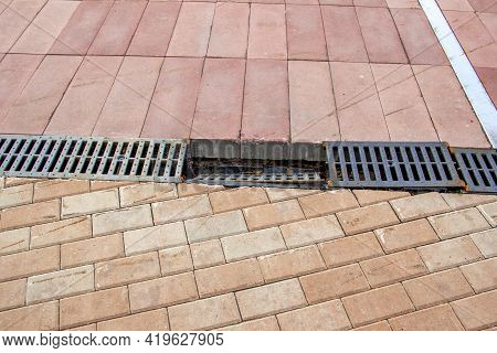 A Piece Of Broken Storm Water On Red Paving Stones A Traumatic Place The Grate Is Torn Off