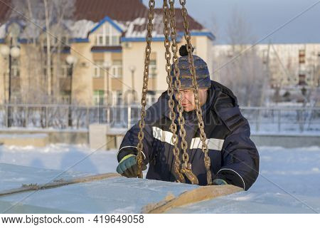 Fitter In A Blue Jacket Works With A Chain Metal Sling