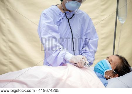 Elderly Patients Lie In Bed, Doctors Use A Stethoscope To Check Lung Function. They Both Wore Face M