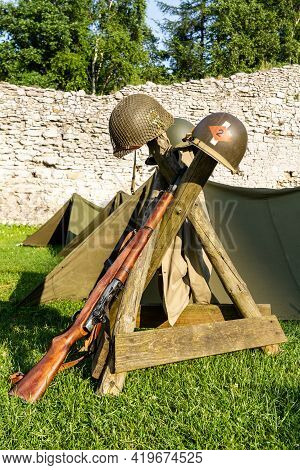 Ww2 Weapons And Helmets  Laid On Display At A Re-enactment.  Part Of The Standard Ordnance Of The Am
