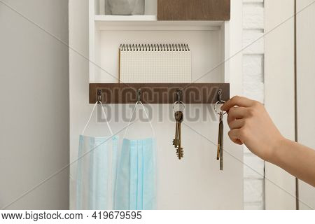Woman Taking Keys From Hanger In Hallway, Closeup