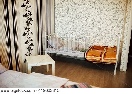 Made-up Bed In The Apartment. Single Cozy Bed. Minimalistic Interior Of The Apartment In Bright Colo