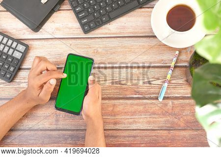 Top View Of Man Hand Using Smart Phone On Office Desk