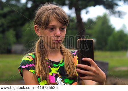 Defocus Surprised Ten Year Old Girl Find Something On Smart Phone. Beautiful Teenage Girl Takes Self