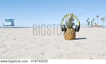Funny Pineapple In Headphones, Sandy Ocean Beach By Blue Lifeguard Hut, California Usa, Pacific Coas