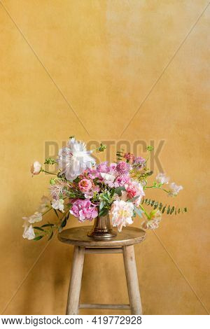 Flowers in a vase on a stool