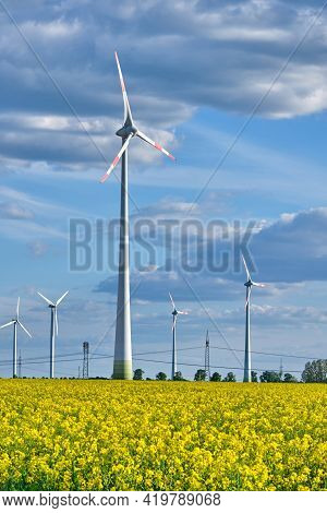 Wind Turbines In A Flowering Canola Field Seen In Germany
