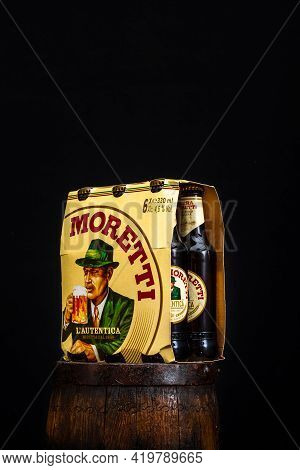 6 Pack Of Birra Moretti Beer On Wooden Barrel With Dark Background. Illustrative Editorial Photo Buc