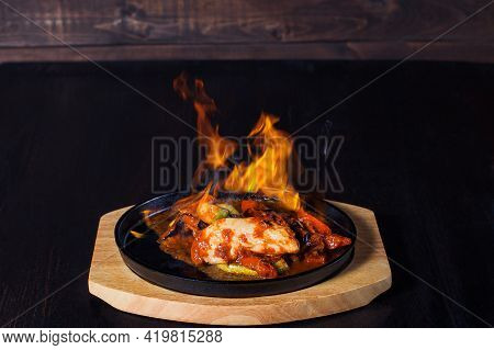 Fajitos, Meat In A Frying Pan With Fire On A Wooden Tray, Beautiful Serving, Dark Background.