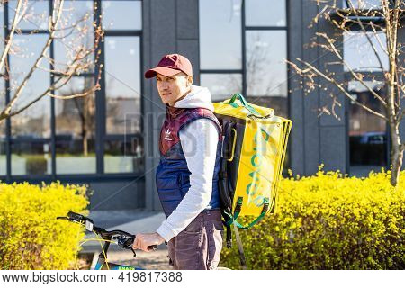 Kiev, Ukraine - April 28, 2021: Glovo Bike Courier On The Street. Delivery Boy Of Glovo Delivery Ser