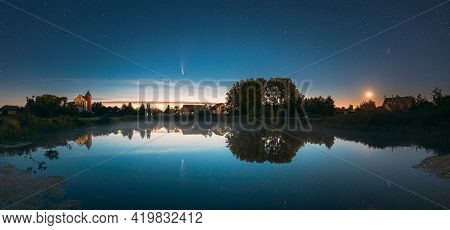 Dobrush, Belarus. Comet Neowise C2020f3 Anf Rising Moon In Night Starry Sky Reflected In Small Lake 