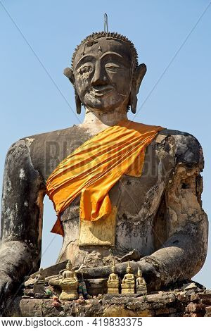 Closeup Of Huge Stone Statute Of Buddha Wrapped In Orange Clock Monastry Phonsavan, Laos.