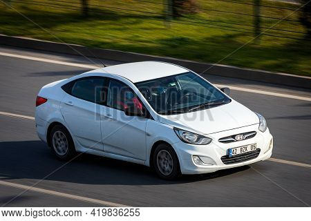 Alanya, Turkey  - April 17  2021:    White Hyundai Solaris   Is Driving Fast On The Street On A Warm