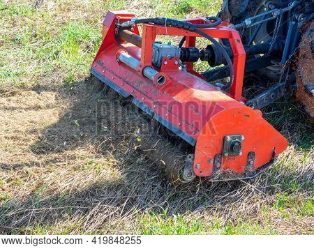Close-up Of A Tractor With A Chain Mower Chopping Dry Grass. Maintenance Of The Territory, Mulching 