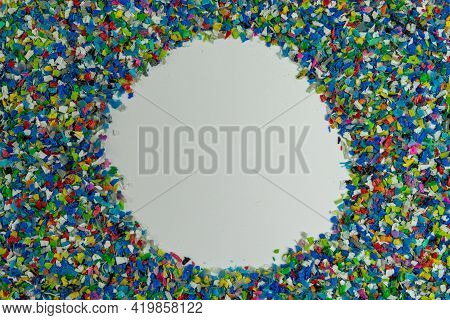 Crushed Plastic On Green Gloved Hand. Reuse Of Plastic. Polymer Beads. Scraps Obtained From Plastic